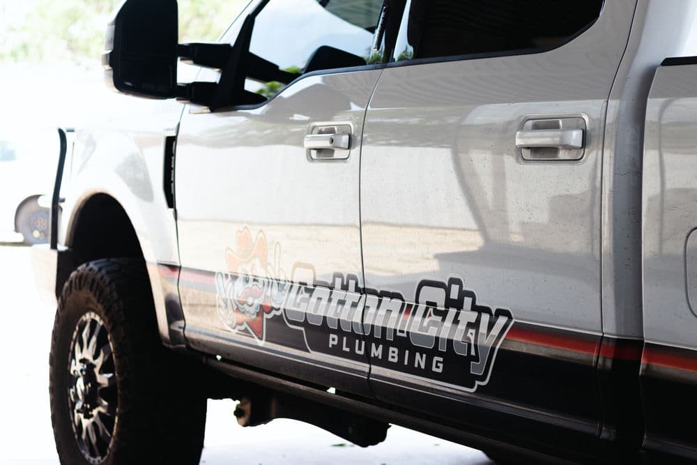 Cotton City Plumbing branded truck parked with logo visible on the side.